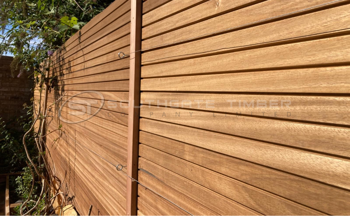 Close-up of a garden fence built with Southgate Timber Thermo Ayous 3-Stripe cladding, shown in its natural untreated state with a smooth golden-brown finish, highlighting the clean horizontal lines and fine grain texture.