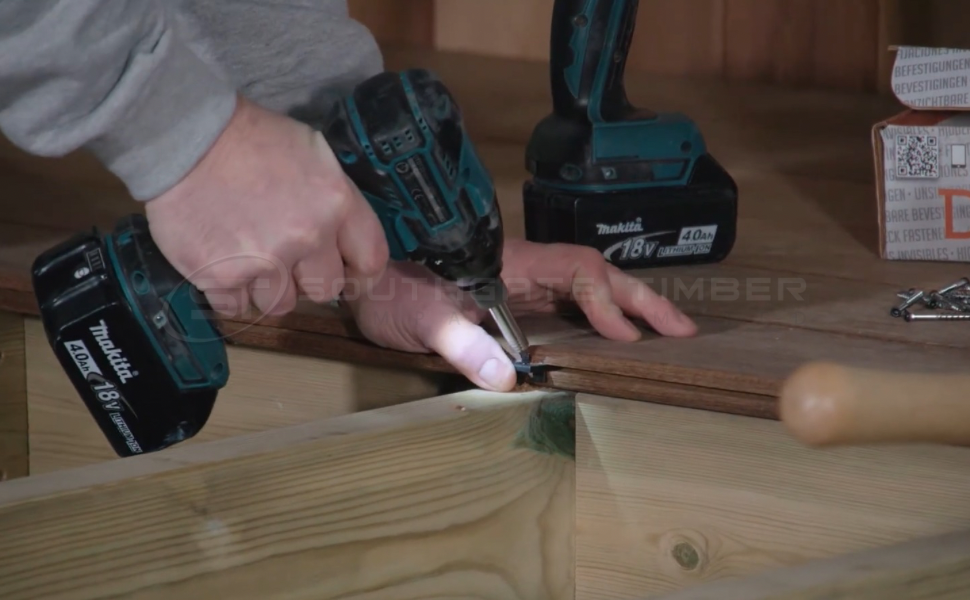 Installer securing Ipe hardwood decking boards with hidden fixings using a Makita drill, demonstrating the importance of choosing durable, weather-resistant fasteners for winter decking projects supplied by Southgate Timber.