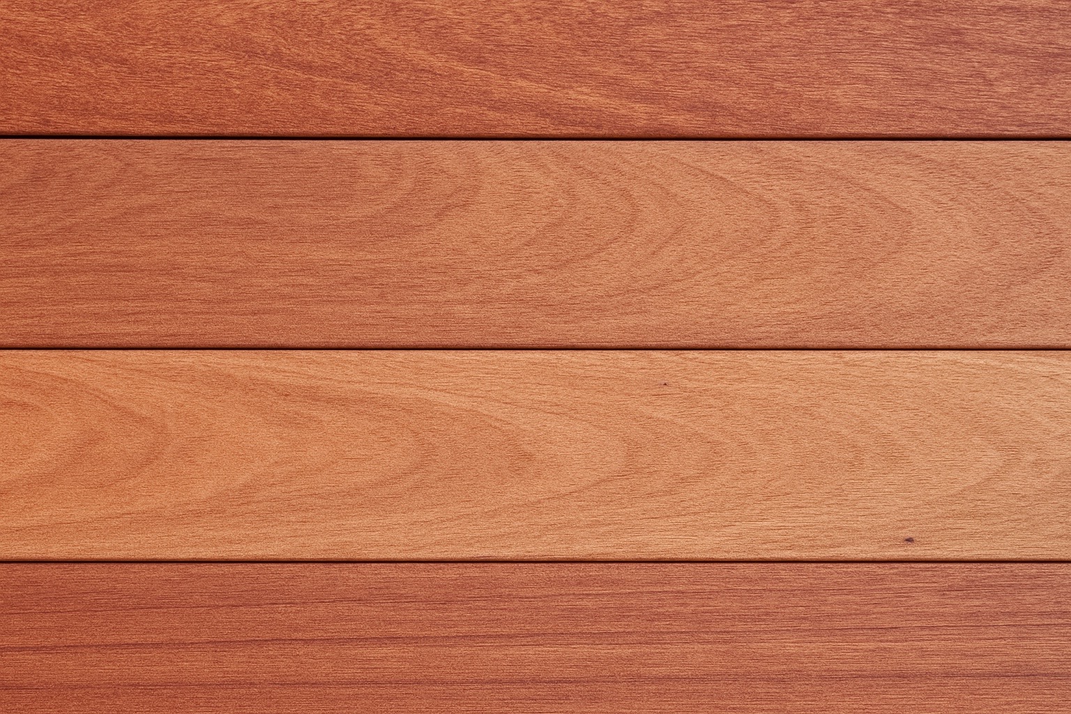 Close-up view of Jatoba hardwood decking boards showing rich reddish-brown colour variation and smooth grain pattern, ideal for durable outdoor decking projects.