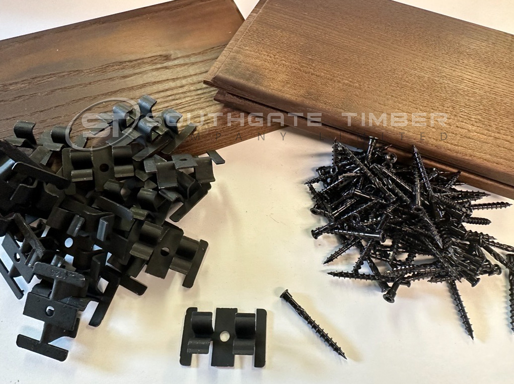Thermo Ash decking installation kit with hidden fixing clips, screws, and boards, demonstrating a clean, modern decking system without visible surface screws.