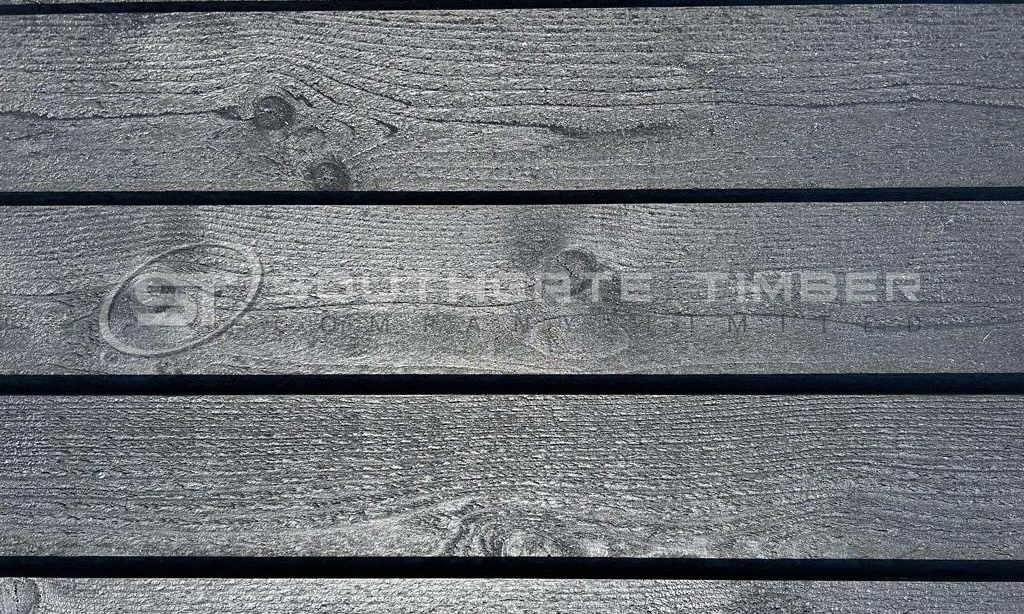 Black Barn 24 x 136mm Classic Bevel cladding boards with a deep charcoal finish and visible wood grain texture, premium exterior cladding from Southgate Timber.