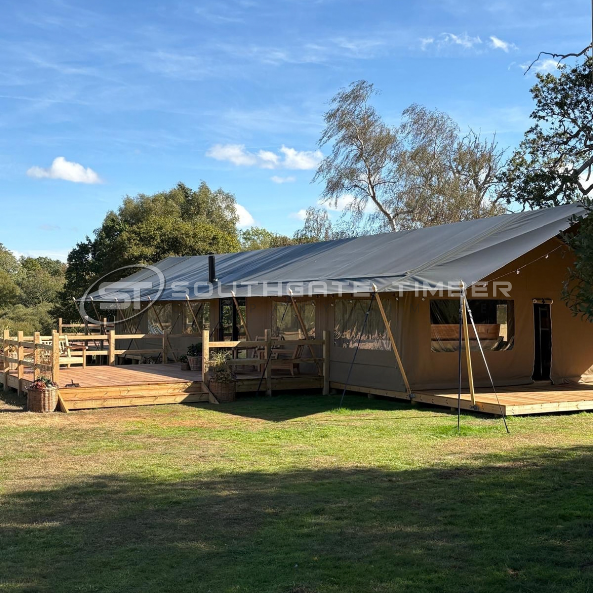 Side view of a safari-style wedding tent and timber terrace in the grounds of Blenheim Palace