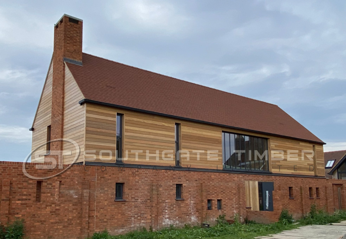 UK house with timber cladding added to upper exterior walls alongside brickwork