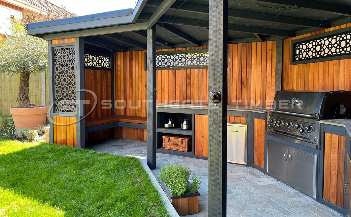 Timber cladding and fencing in garden outdoor kitchen area showing maintained natural finish