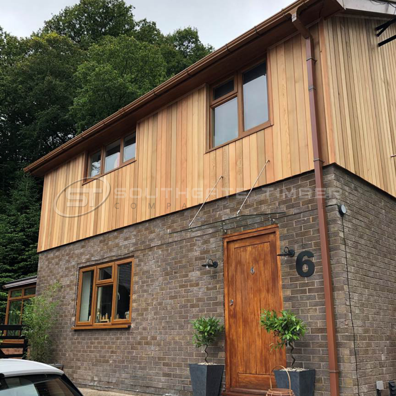 Timber cladding installed over brick exterior wall on a modern UK home renovation project