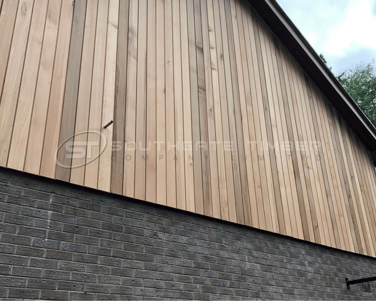 Vertical timber cladding installed over exterior brick wall using concealed fixing and batten system